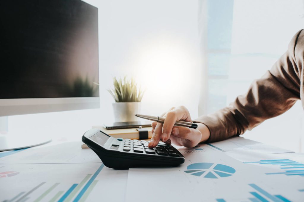 accountant with calculator looking a graphs